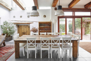 Bright dining area with big dining table and chairs in a modern farmhouse _ getty