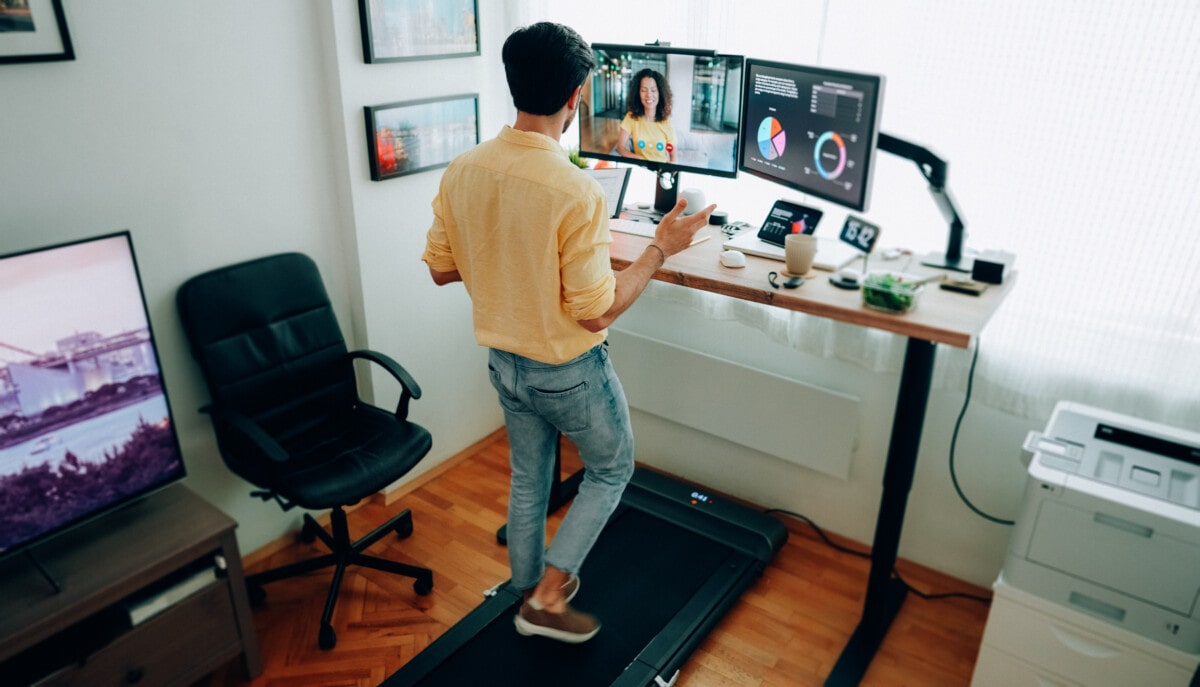 Man at standing desk home office talking on business video call