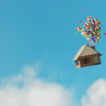 A house floating with balloons