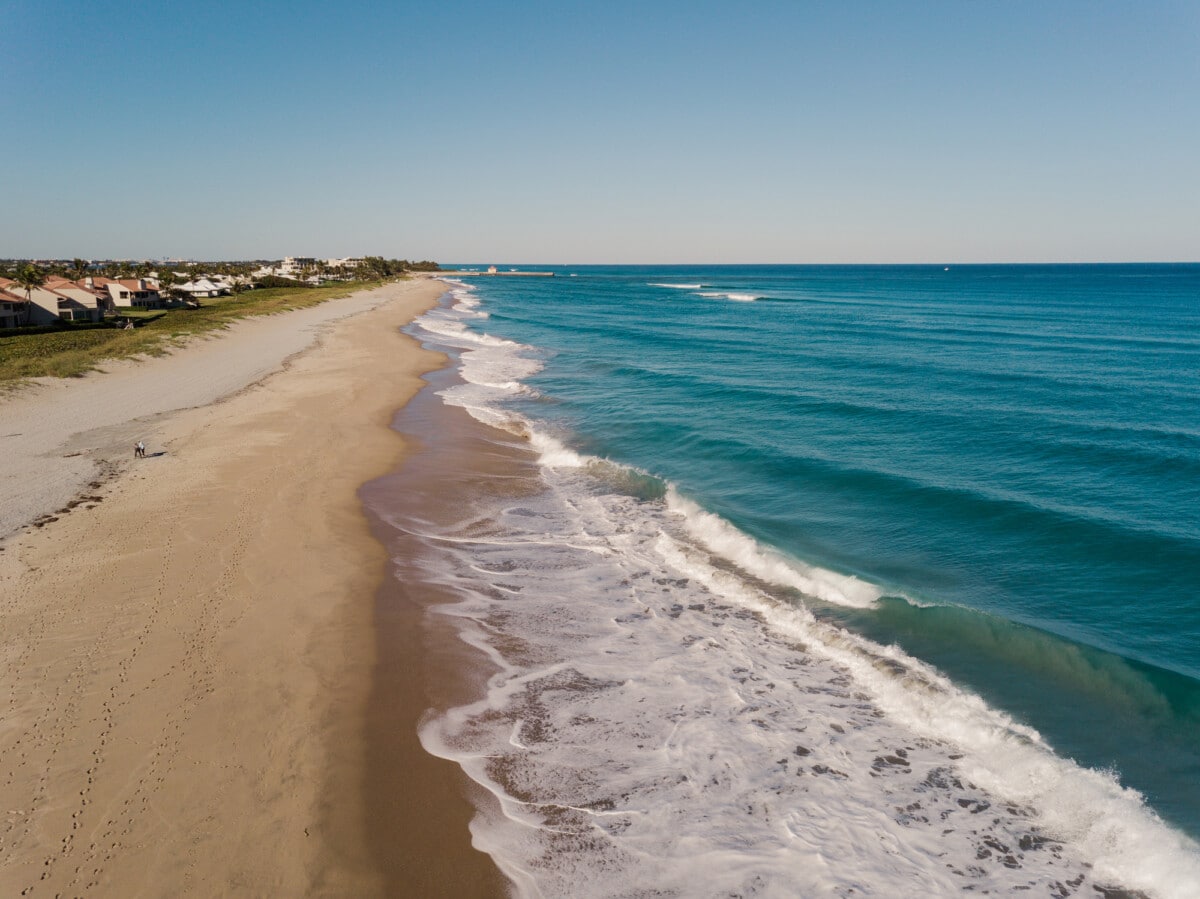 Luftaufnahmen von blaugrünen Wellen, die an einem Wochentag im Februar 2021 über die Küste von Boynton Beach, Florida, fegen.