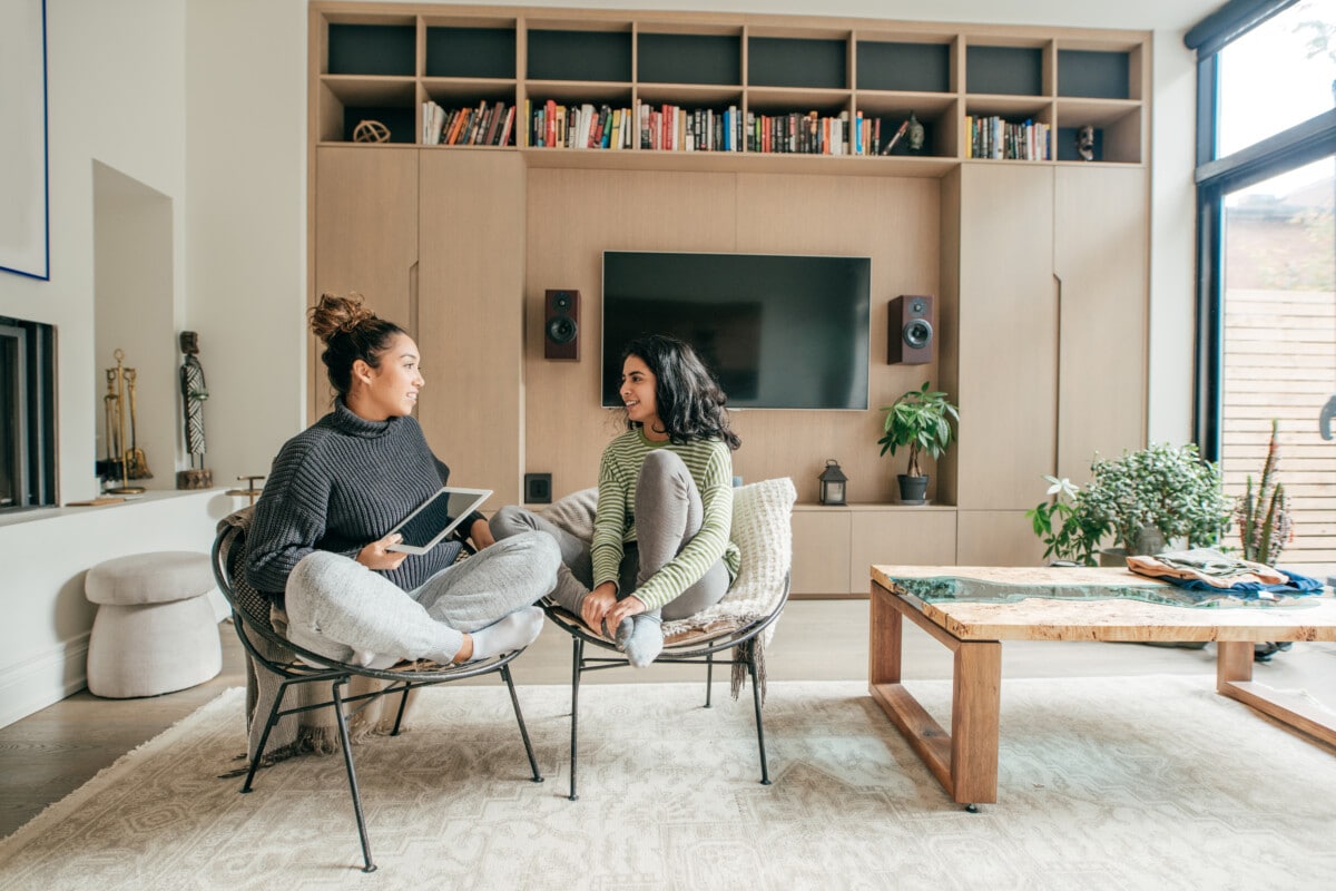 Two female friends sitting in a living room