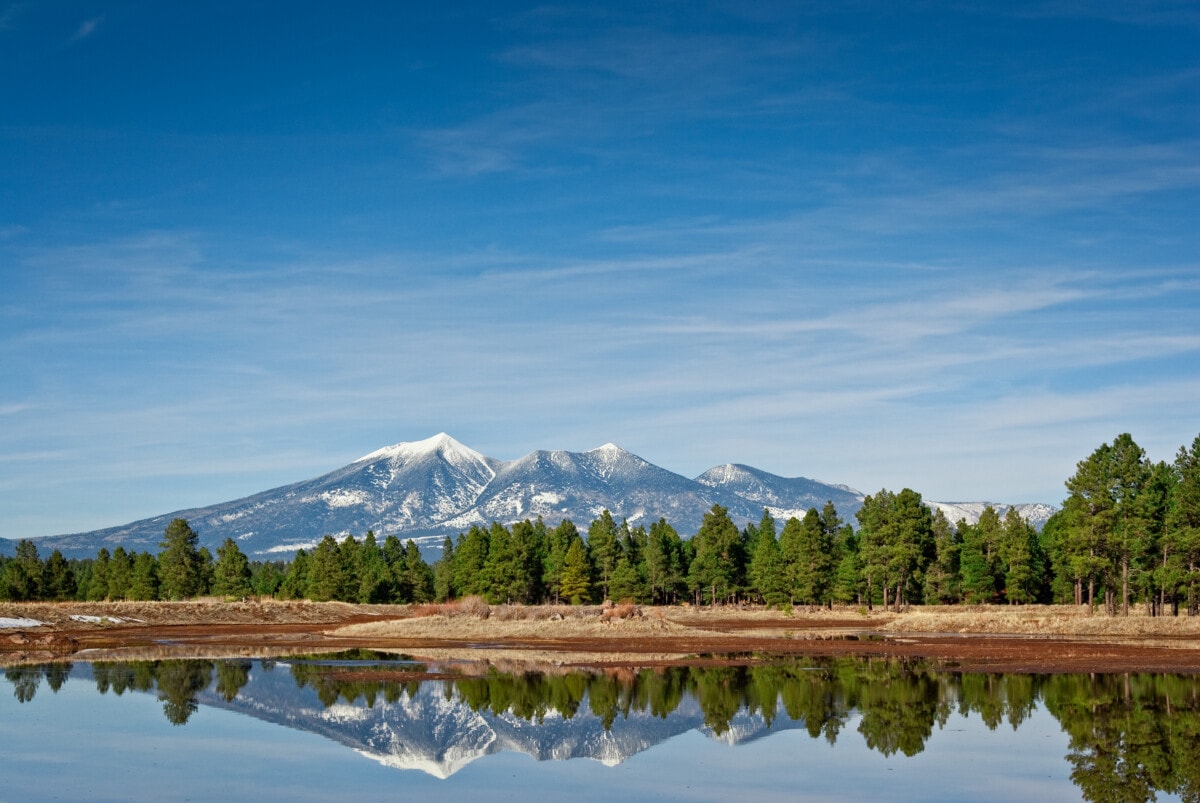 snowcapped mountain, trees, and lake in flagstaff
