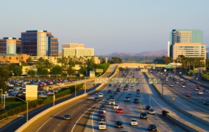 "Irvine office buildings on both sides of the 405 freeway. Irvine has the largest highrise office / business district in Orange County, and is located just beside the John Wayne Airport, the commercial airport that serves Orange County."