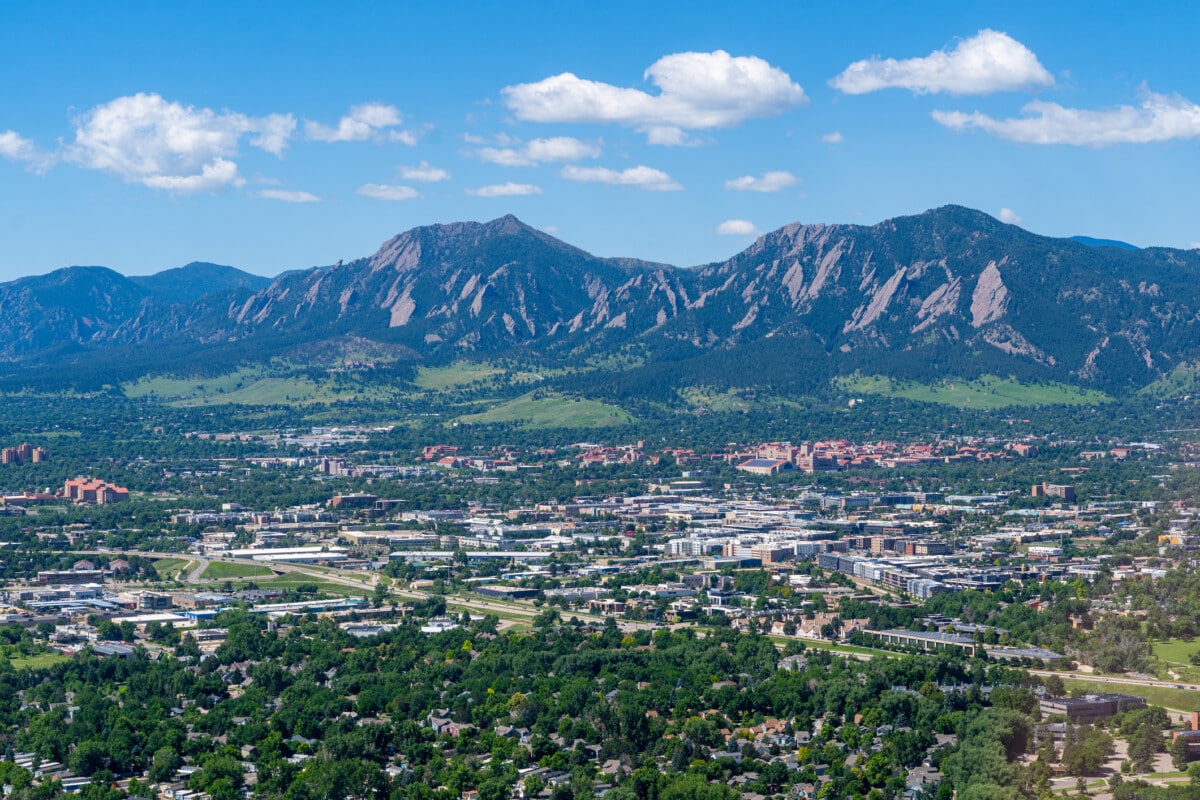 Aerial photo above Boulder Colorado on a clear day looking southwest towards University of Colorado and Flatiron Mountains and the city of Boulder with Highway 157 (Foothills Parkway) cutting across the foreground