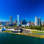 Downtown Milwaukee skyline view with the shoreline of Lake Michigan in the foreground.