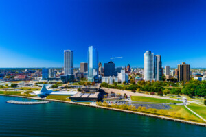 Downtown Milwaukee skyline view with the shoreline of Lake Michigan in the foreground.