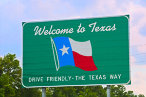 Texas welcome sign coming from the east on Interstate 10 with colored clouds