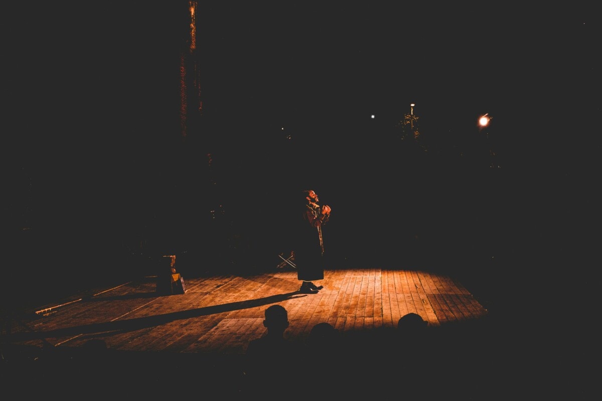 An actor stands on a stage performing a scene