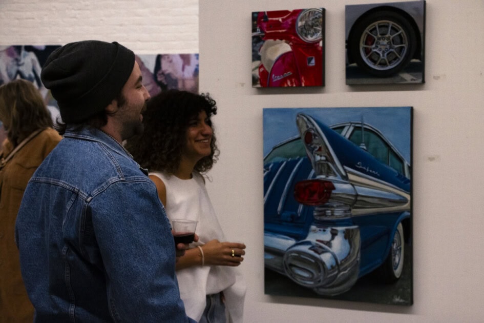 Two people looking at three painting at Art After Dark, a special art experience mentioned in the San Luis Obispo bucket list