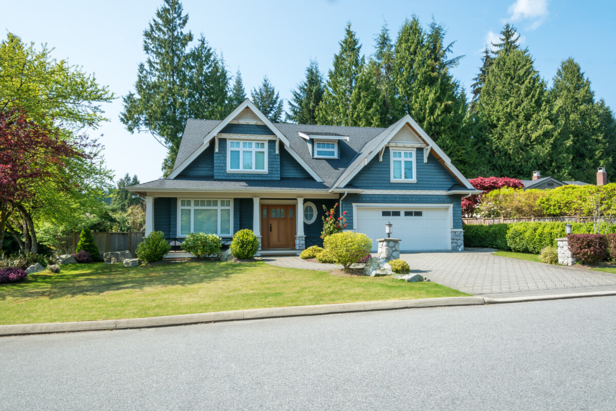 Luxury blue house with beautiful landscaping on a sunny day. Home exterior.