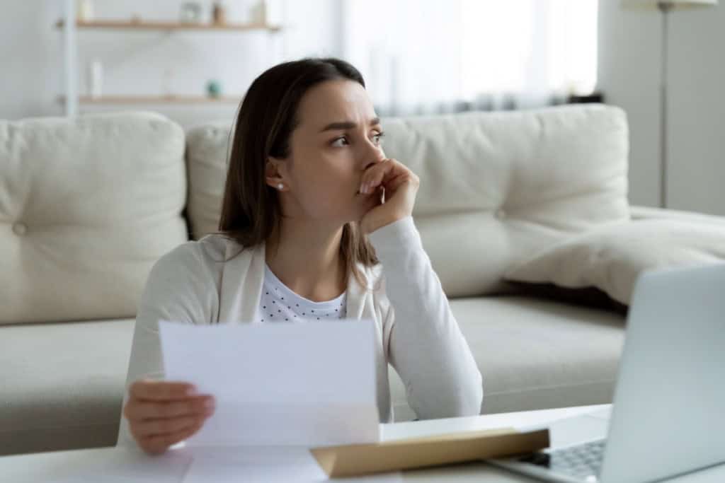 Stressed out woman looking over home sale paperwork