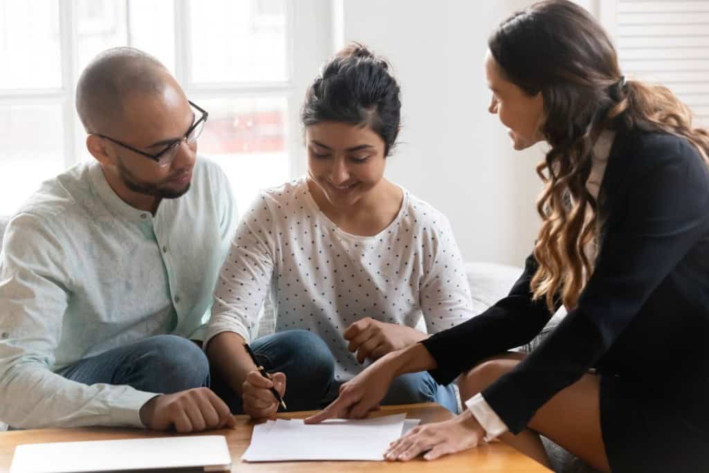 A young couple looks over legal documents after selling their house