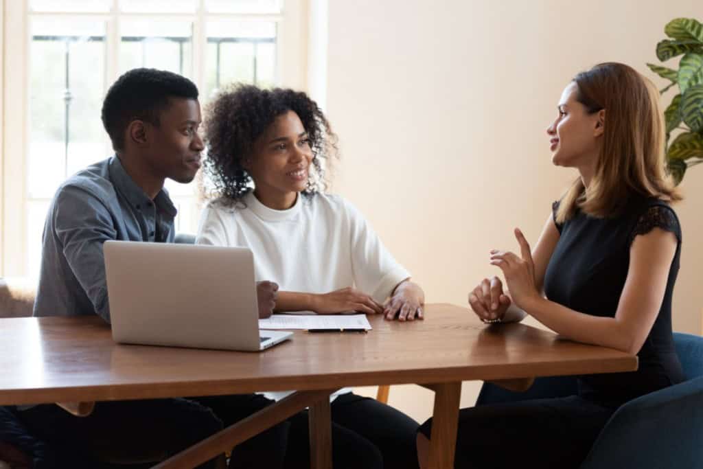 Couple talking over their recent home purchase with an agent