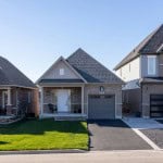 Small grey brick home in a subdivision.