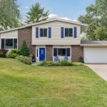 Home for sale in Minneapolis, MN with a large lawn and blue shutters.
