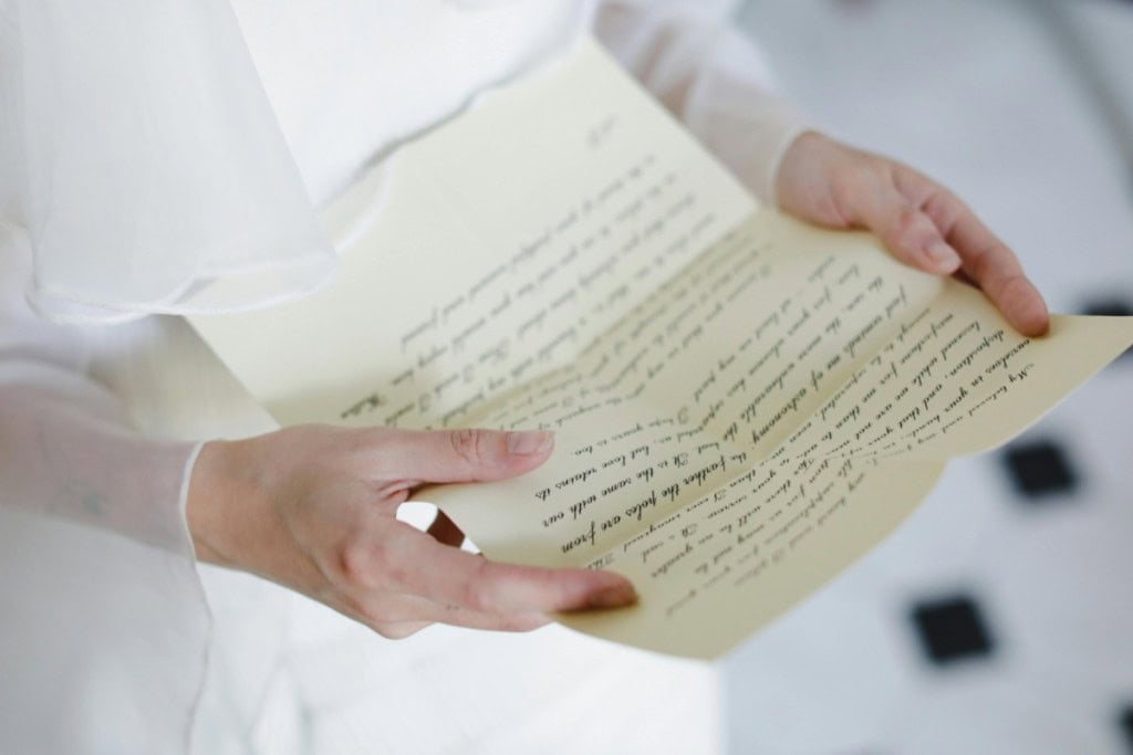 Person holding a handwritten letter to seller of home.
