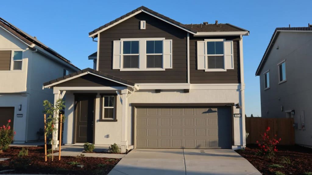 Brown house with a front facing garage that could be subject to gift tax if given to someone instead of being sold.
