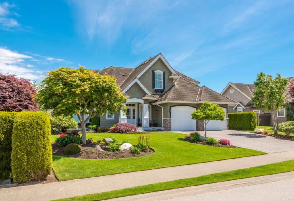 A large, new home in a grassy suburban neighborhood.